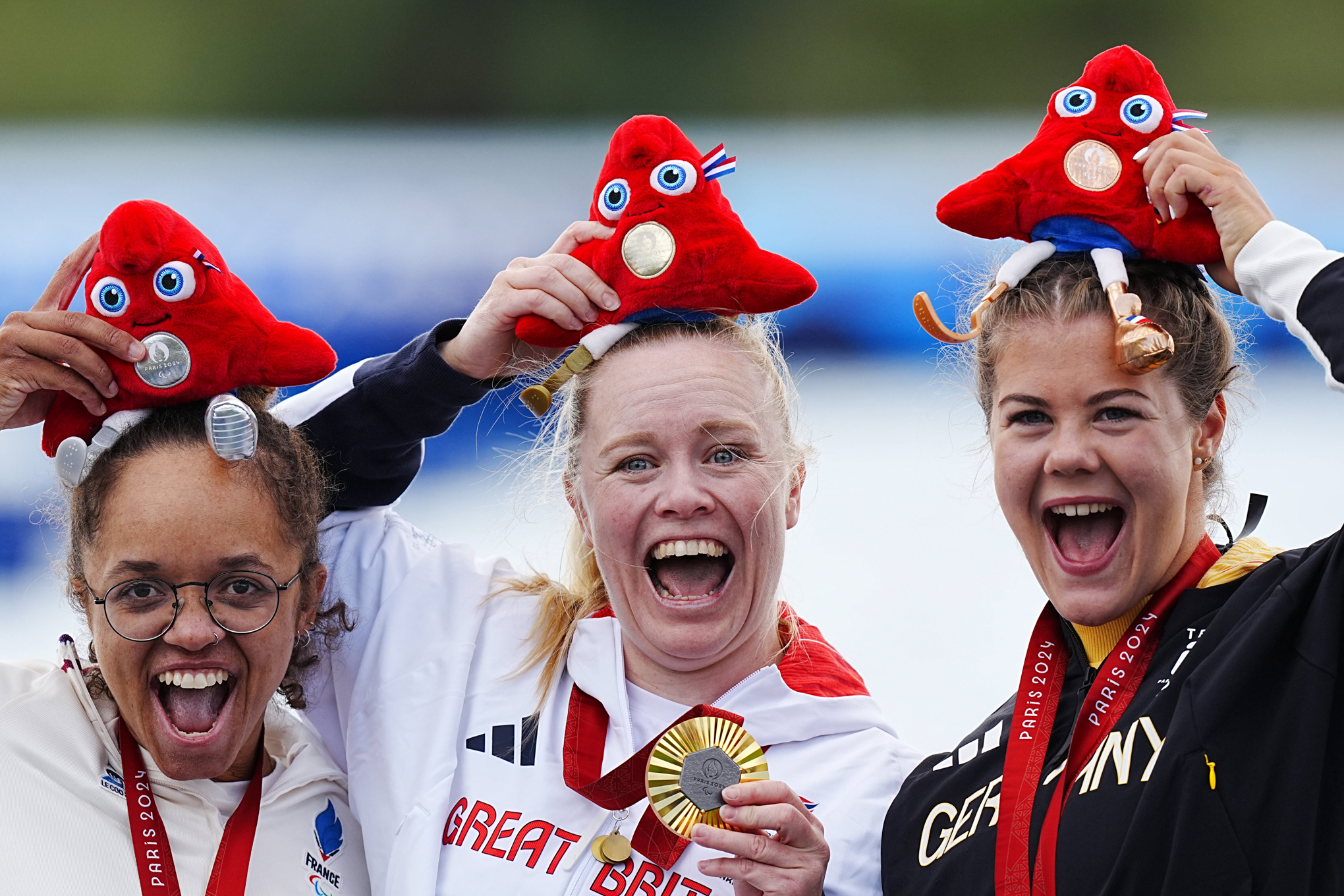 Great Britain's Laura Sugar (centre) celebrates with the gold medal on the podium after winning the Women's Kayak Single 200m - KL3 Final, alongside France's Nelia Barbosa (left) who won silver and Germany's Felicia Laberer who won bronze at the Vaires-sur-Marne Stadium on day eleven of the Paris 2024 Summer Paralympic Games. Picture date: Sunday September 8, 2024. - Photo by Icon Sport